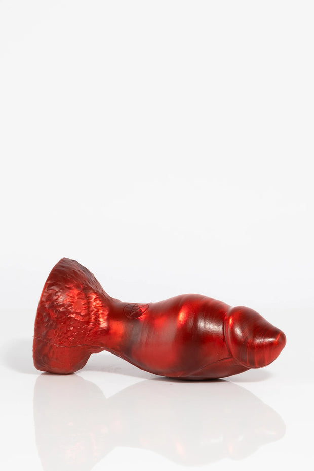 A product photo of a red Minotaur dildo laid down.