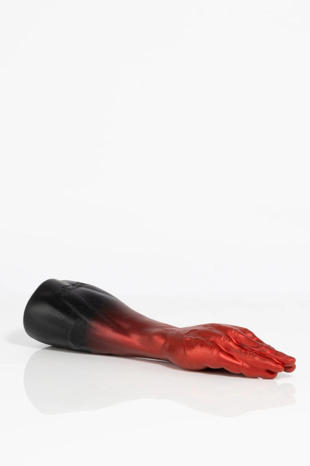A product photo of an ombre coloured fist dildo lying down.