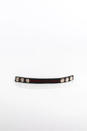 A product photo of a black pentagram-studded cock ring with a red trim.