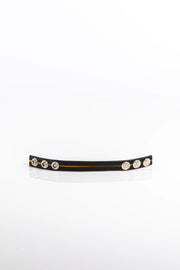 A product photo of a black leather pentagram-studded cock ring with yellow trim.