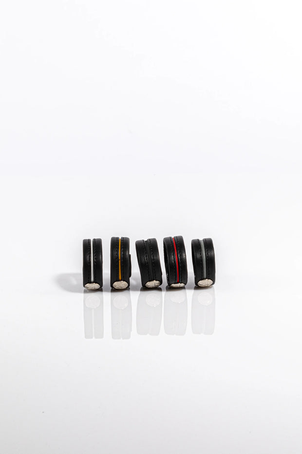 A product photo of five different coloured pentagram-studded cock rings.