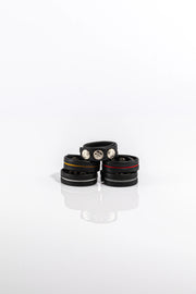 A product photo of five black and coloured pentagram-studded cock rings. 