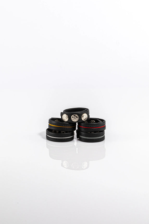 A product photo of five black and coloured pentagram-studded cock rings. 