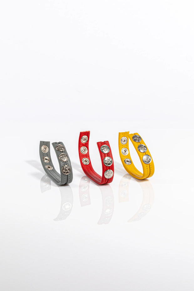 A product photo of three solid coloured pentagram-studded leather cock rings.