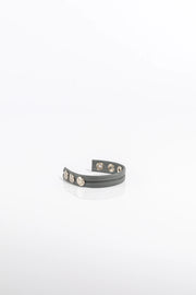 A product photo of a solid grey pentagram-studded cock ring.