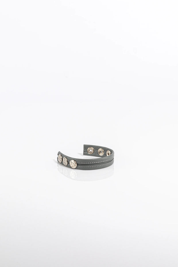 A product photo of a solid grey pentagram-studded cock ring.