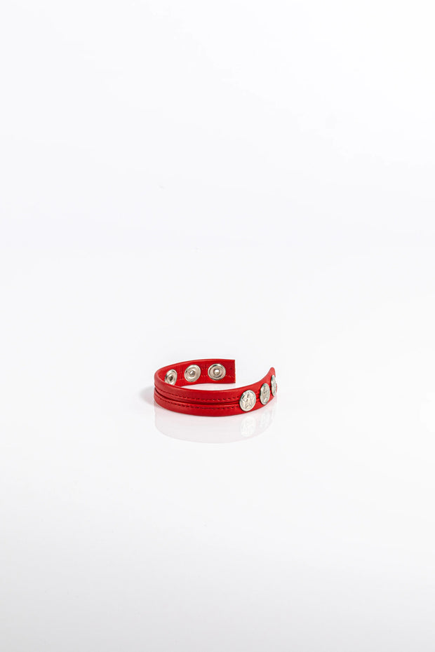 A product photo of a solid red pentagram-studded cock ring.