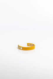 A product photo of a solid yellow pentagram-studded leather cock ring.