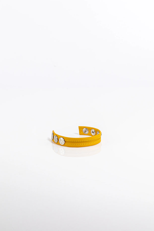 A product photo of a solid yellow pentagram-studded leather cock ring.